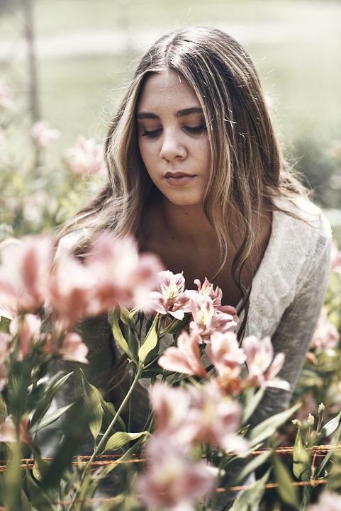 Retrato de quinceañera en Córdoba rodeada de flores y luz suave
